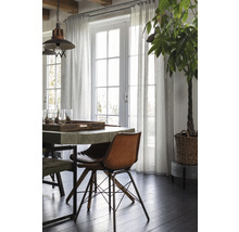 Lichte eetkamer met eettafel, stoelen, gordijnen en kamerplant
