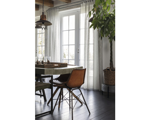 Lichte eetkamer met eettafel, stoelen, gordijnen en kamerplant