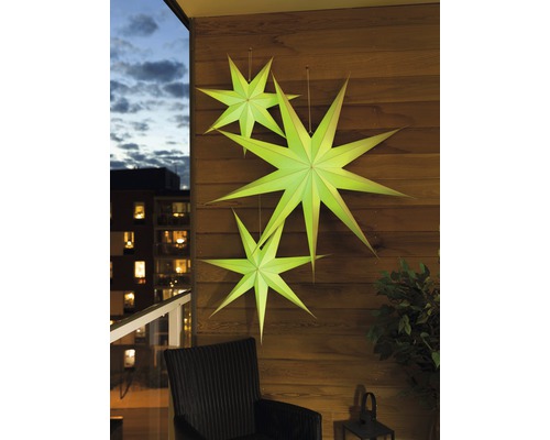 Decoratieve papieren sterren aan een houten wand op een balkon