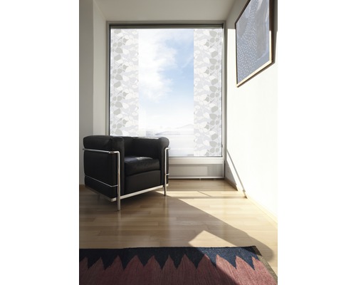 Woonkamer met schuifgordijnen, fauteuil en vloerkleed