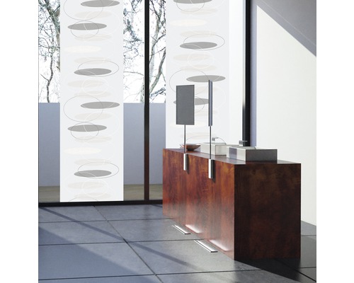 Kamer met schuifgordijnen met cirkelpatroon, wastafel en groot raam.