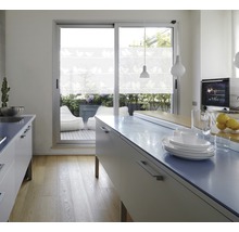 Lichte keuken met kookeiland, servies en uitzicht op een terras met zitzakken