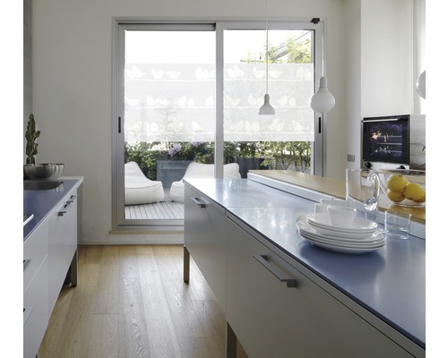 Lichte keuken met kookeiland, servies en uitzicht op een terras met zitzakken