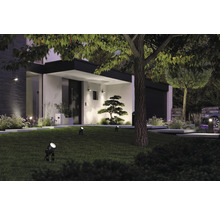 Verlichte tuin met gazon, bomen en moderne gevel