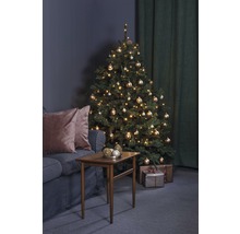 Kerstscène met verlichte kerstboom, tafel en bank