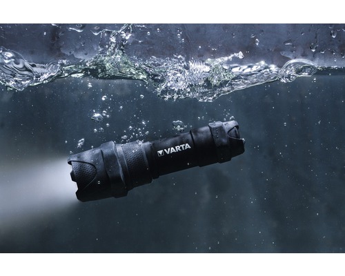 Zwarte Varta zaklamp onder water met lichtstraal