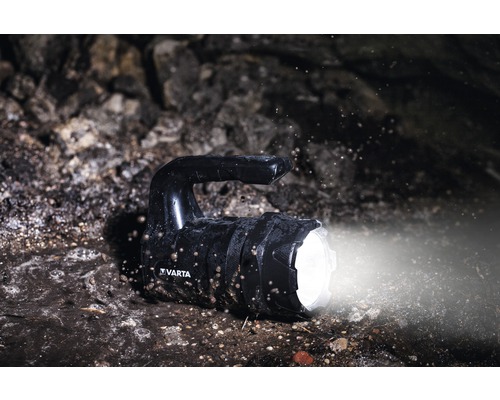 Zwarte Varta handlamp op vuile ondergrond