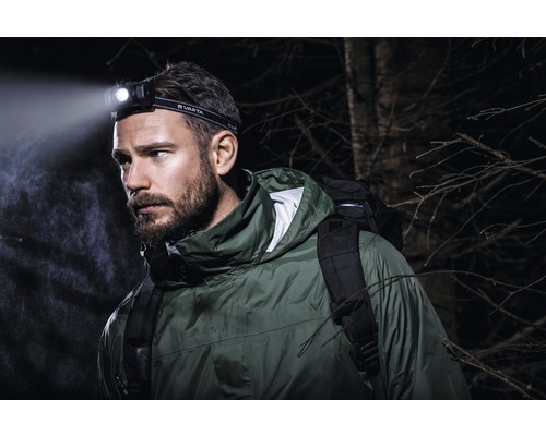 Man met Varta hoofdlamp en rugzak buiten