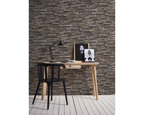 Inrichting met bureau, stoel, lamp en wand in steenlook voor werkkamer of kantoor.