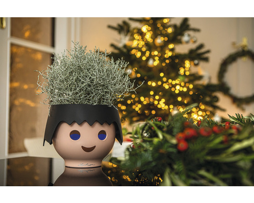 Decoratieve kamerplant in een plantenbak in de vorm van een kind voor een kerstboom