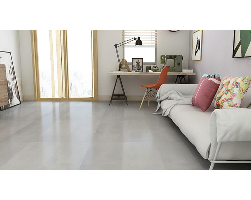 Lichte woonkamer met bank, bureau en raam voor een vriendelijke sfeer.