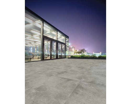 Buitenvloertegels gelegd voor een modern gebouw in de nacht.