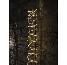 Decoratieve lichtsnoer op een metalen rooster met takken voor een bakstenen muur