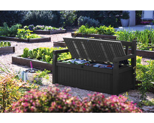 Geopende tuinbankbox in de tuin met tuingereedschap.