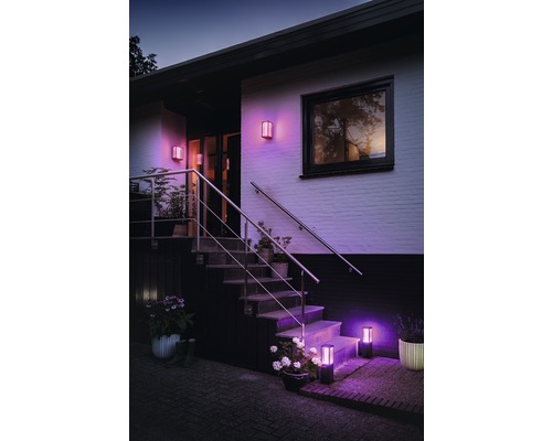 Gevel met verlichte buitenlampen op muur en trap