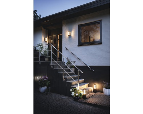 Buitenkant van een huis met trap en buitenverlichting die een uitnodigende sfeer creëert.