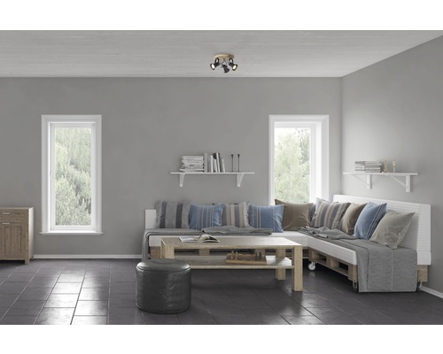 Woonkamer met ramen, palletmeubels en plafondlamp met drie spots