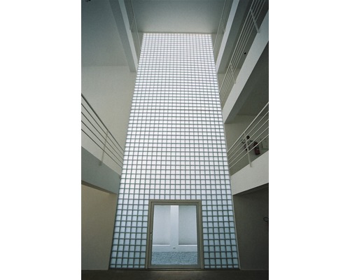 Interieurbeeld van een gebouw met een muur van glasstenen en een deur