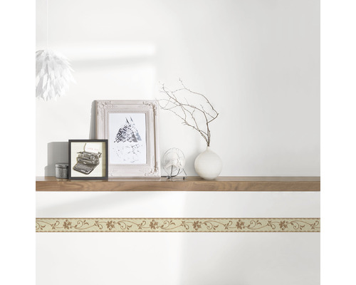 Wand met bloemenrand en decoratie op een houten plank