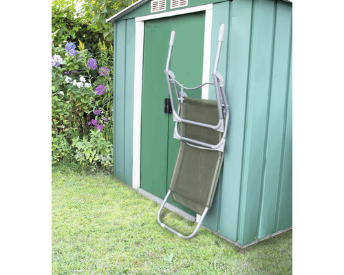 Groen tuinhuis met een ingeklapte ligstoel