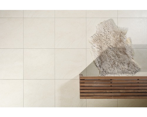 Lichte vloertegels met houten bank en schapenvacht
