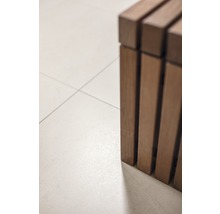 Detailaanzicht van een houten bank op een tegelvloer.