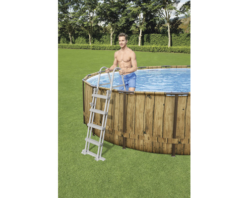 Ovaal zwembad met houten bekleding en ladder in de tuin.