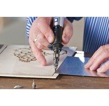 Persoon graveert hout met een Dremel gereedschap