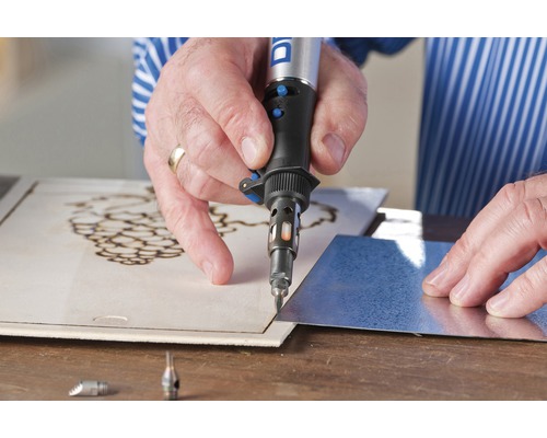 Persoon graveert hout met een Dremel gereedschap