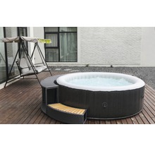 Opblaasbare whirlpool met ombouw en schommelstoel op een houten terras.