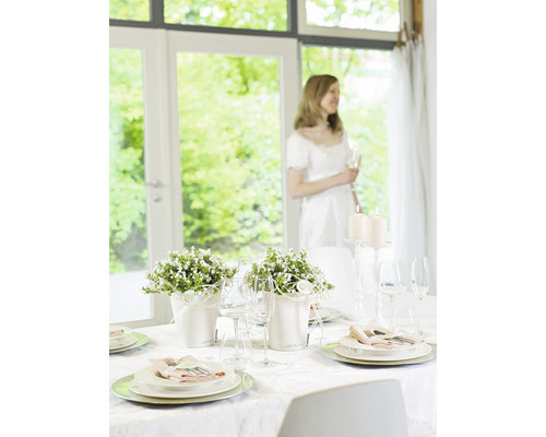 Feestelijk gedekte tafel met bloemstukken en kaarsen voor een speciale gelegenheid.