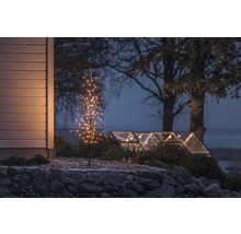 Decoratieve boom met verlichting buitenshuis in de schemering