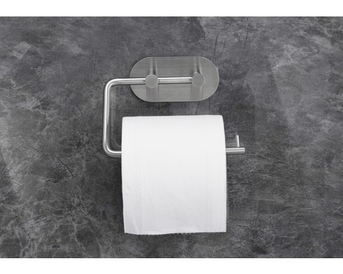 Toiletpapierhouder met rol toiletpapier op een grijze muur