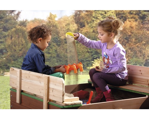 Twee kinderen spelen in een zandbak met zandspeelgoed.