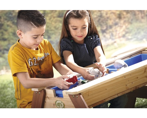 Twee kinderen spelen met een zandbak in de buitenlucht.