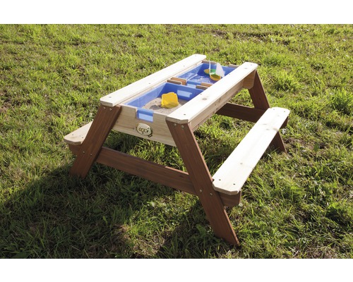 Zandbak met tafel en banken van hout op een gazon