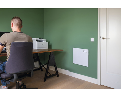 Kantoor met verwarmingspaneel aan de muur, bureau en bureaustoel.