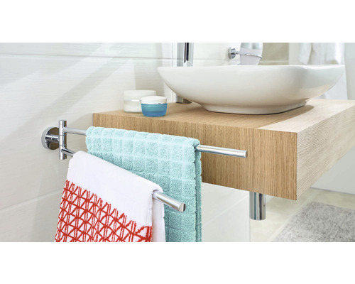 Moderne badkamer met wastafel, metalen handdoekrek en handdoeken.