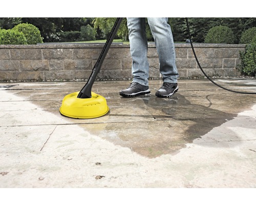 Oppervlaktereiniger in gebruik op een stenen terras