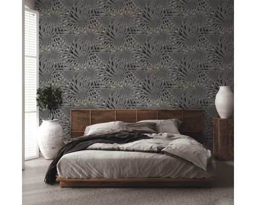 Slaapkamer met bed en behang met bladerpatroon