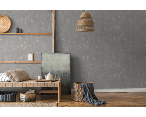 Woonkamer met grijs cirkelbehang, houten plank, daybed en decoraties voor een lichte en uitnodigende sfeer.