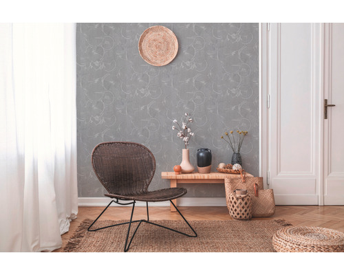 Decoratieve woonkamer met rotan stoel, patroonbehang en houten vloer