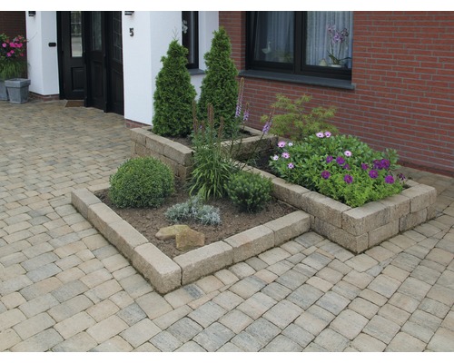 Buitenkant met straatstenen en beplante stenen bakken