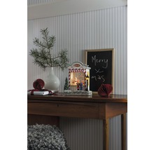 Decoratief kerststilleven met verlichte sneeuwbol op een houten tafel