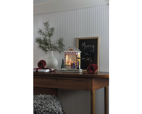 Decoratief kerststilleven met verlichte sneeuwbol op een houten tafel
