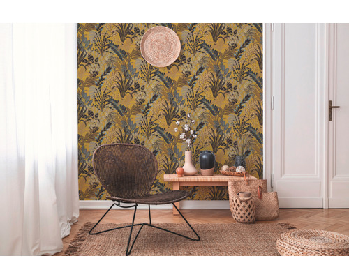 Woonkamer met patroonbehang, fauteuil en decoratieve accessoires voor een gezellige sfeer.