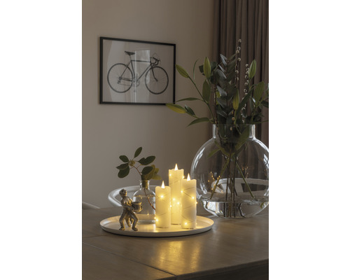 Decoratief arrangement met LED kaarsen, vazen en een sculptuur op een tafel