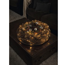 Decoratieve krans met LED-lichtslinger en kerstversiering op een tafel