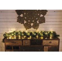 Dressoir met decoratieve slinger, lichtsnoer en wanddecoratie