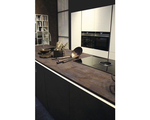 Keukenscène met donkere onderkasten, werkblad met verlichting en witte bovenkasten.